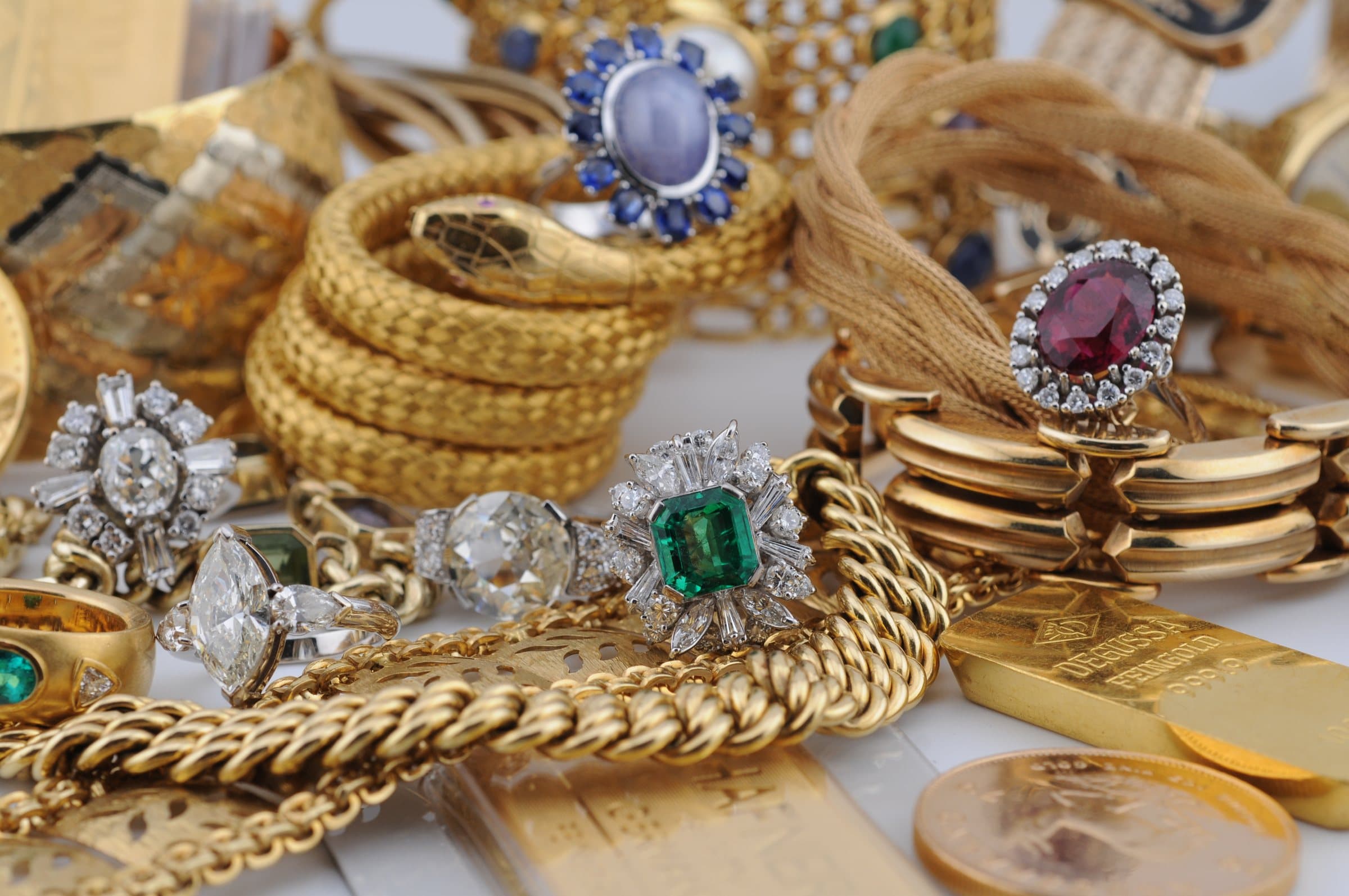 Goldschmuck, Goldbarren und Goldmünzen mit Saphir-, Rubin- und Smaragdringen