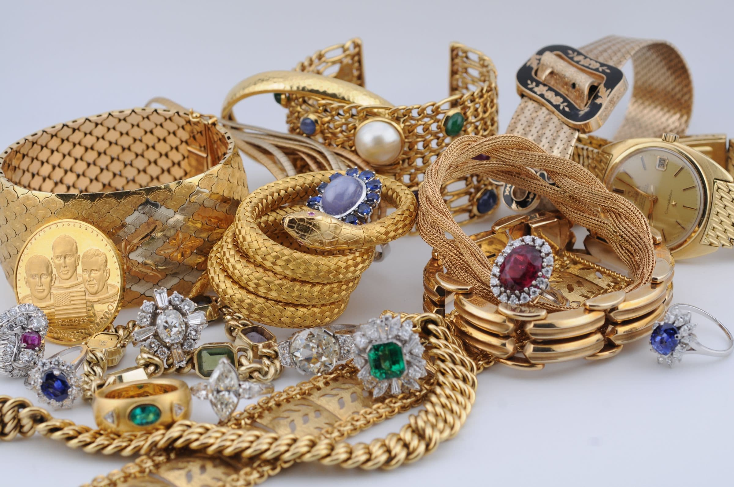 Goldschmuck, Goldbarren und Goldmünzen mit Ringen aus Diamanten, Saphiren, Rubinen und Smaragden